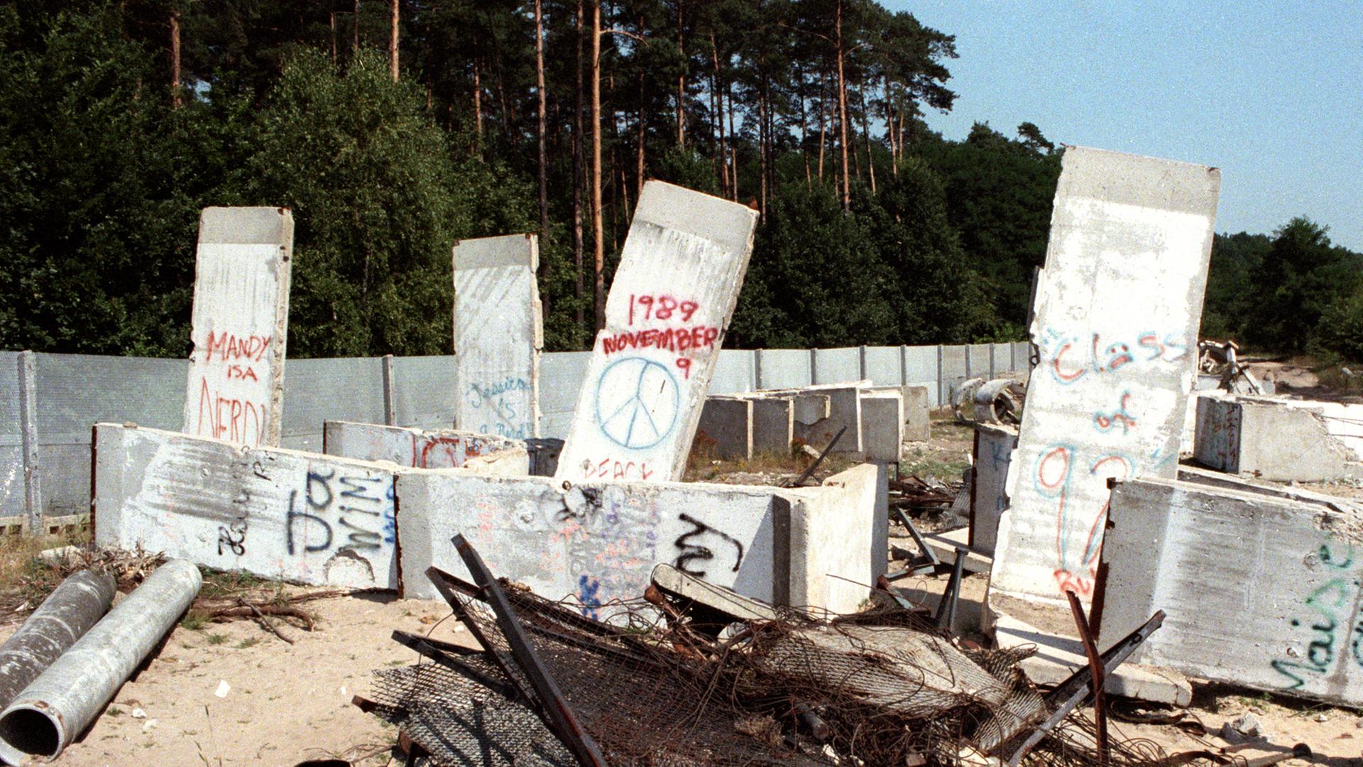 Trümmer der Geschichte - Teile der Betonmauer, Stacheldraht, Gitterzaun und Betonreste der Berliner Mauer liegen im Ortsteil Steinstücken bei Potsdam auf einem Gelände, aufgenommen im August 1990. Trümmer der Geschichte - Teile der Betonmauer, Stacheldraht, Gitterzaun und Betonreste der Berliner Mauer liegen im Ortsteil Steinstücken bei Potsdam auf einem Gelände, aufgenommen im August 1990.