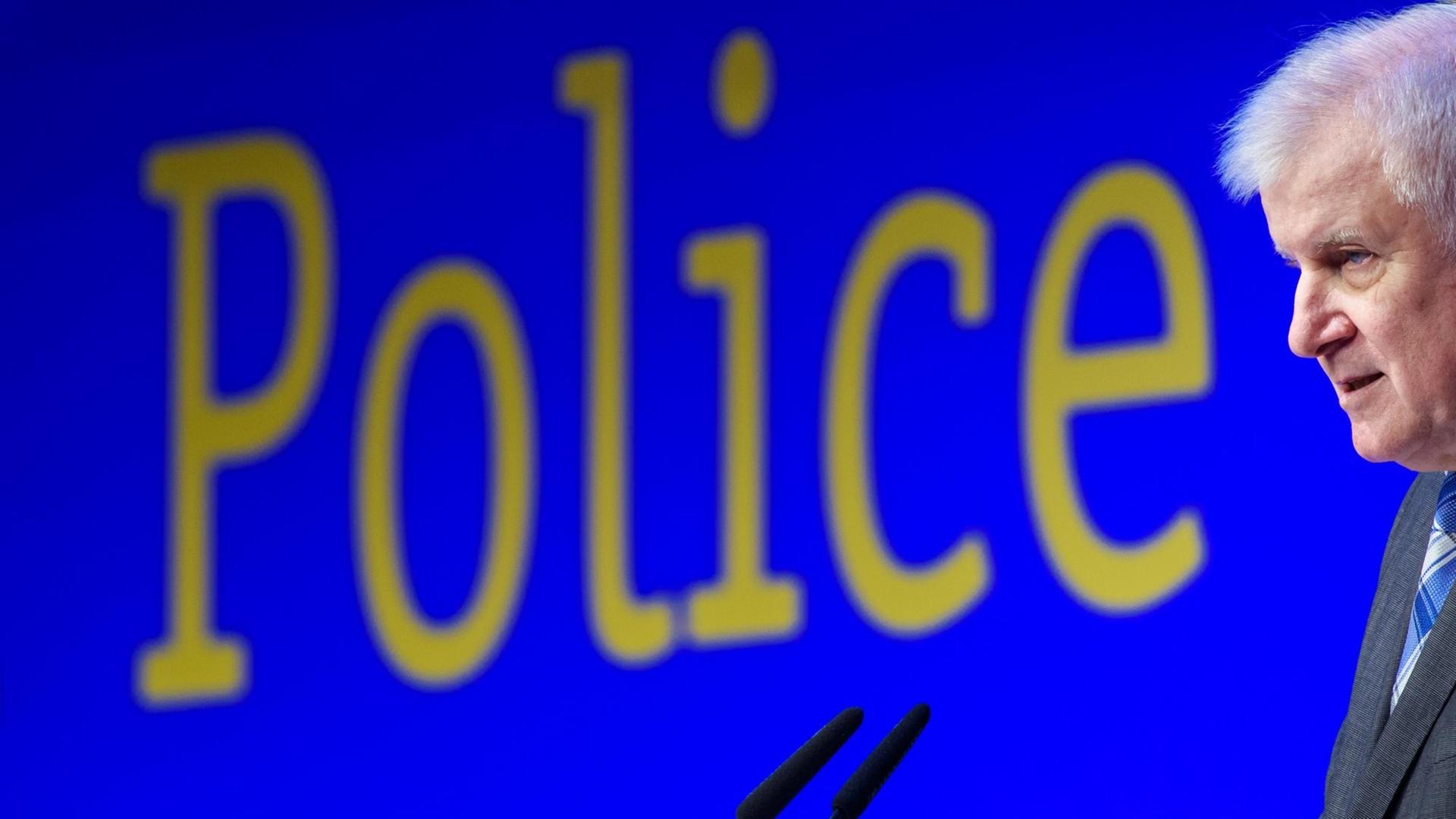 Innenminister Seehofer spricht in ein Mikrofon. An der Wand hinter ihm steht das englische Wort "Police" Innenminister Seehofer spricht in ein Mikrofon. An der Wand hinter ihm steht das englische Wort "Police"