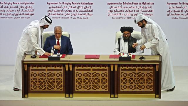 Der US-Sonderbeauftragte Zalmay Khalilzad und der Taliban-Mitbegründer Mullah Abdul Ghani Baradar unterzeichnen in der katarischen Hauptstadt Doha ein Abkommen für Afghanistan.