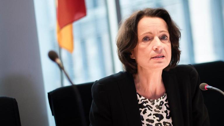 Freitag sitzt an einem Tisch vor einem Mikrofon. Hinter ihr eine helle Fensterfront und eine Deutschland-Fahne. Freitag sitzt an einem Tisch vor einem Mikrofon. Hinter ihr eine helle Fensterfront und eine Deutschland-Fahne.