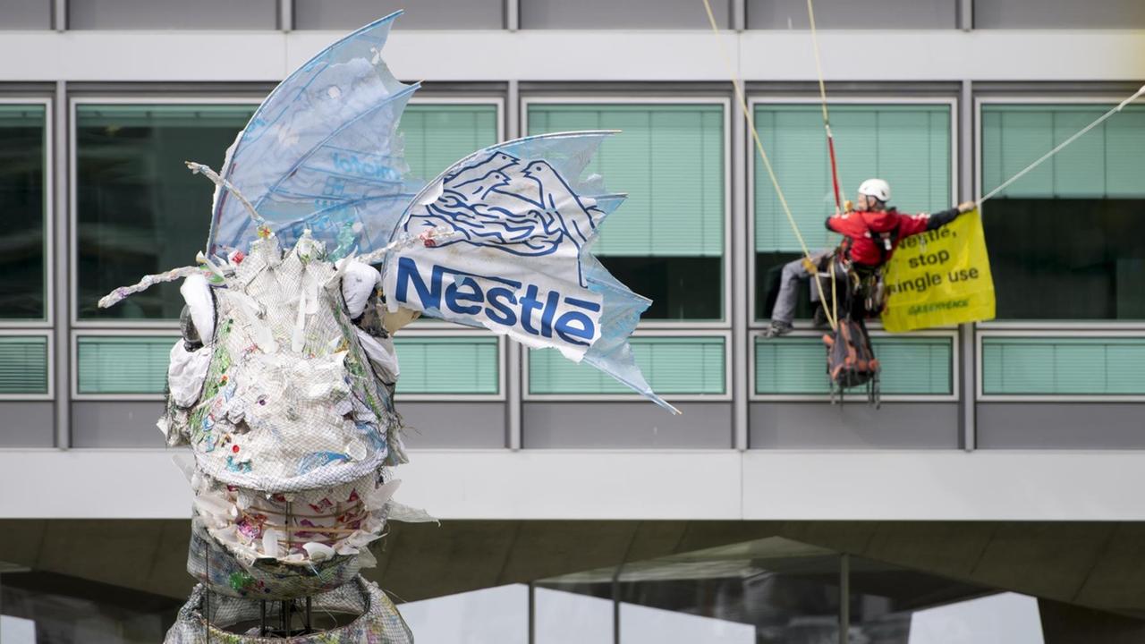 Greenpeace-Aktivisten bringen dem Lebensmittel- und Getränkegiganten Nestlé ein riesiges Monster aus Plastik zurück, das Greenpeace auf See und an den Stränden vor dem Hauptsitz von Nestle in Vevey, Schweiz geborgen hat. Greenpeace-Aktivisten bringen dem Lebensmittel- und Getränkegiganten Nestlé ein riesiges Monster aus Plastik zurück, das Greenpeace auf See und an den Stränden vor dem Hauptsitz von Nestle in Vevey, Schweiz geborgen hat.