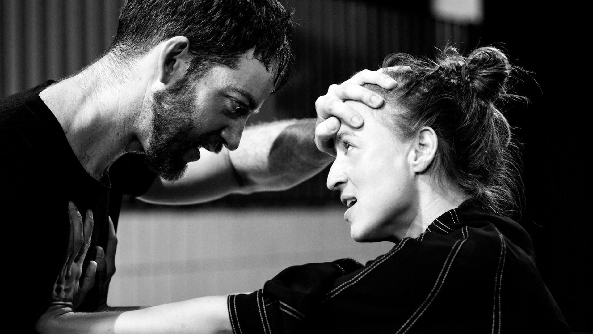 Eine weibliche Performerin und ein männlicher Performer beim Tanz sich gegenüber stehend in einer schwarz-weißen Nahaufnahme ihrer Oberkörper Eine weibliche Performerin und ein männlicher Performer beim Tanz sich gegenüber stehend in einer schwarz-weißen Nahaufnahme ihrer Oberkörper