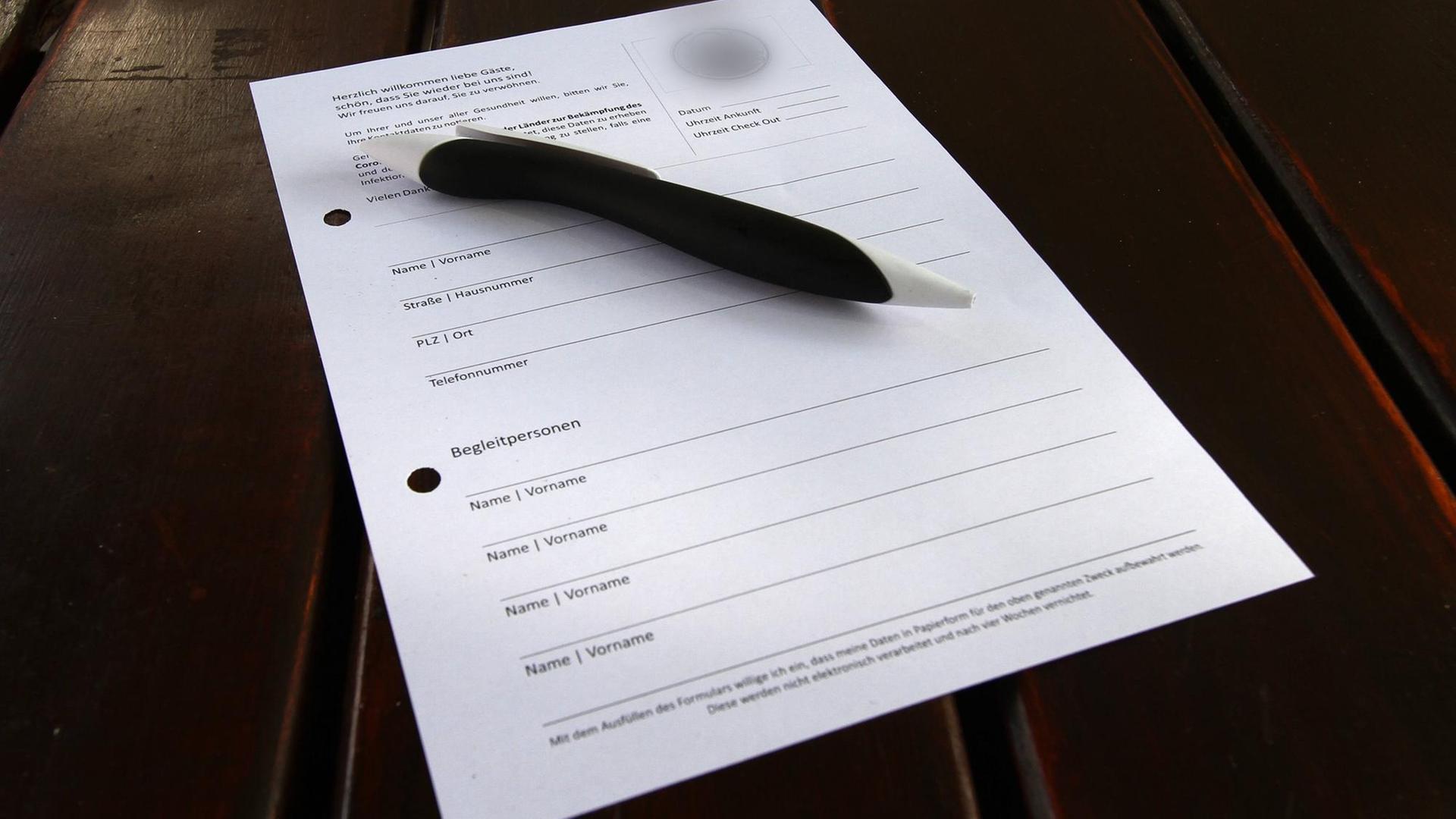Kontaktbogen zur Erfassung persönlicher Daten für eine mögliche Nachverfolgung von Kontaktketten liegt mit einem desinfizierten Kugelschreiber auf einem Tisch im Außenbereich einer Gaststätte in der Innenstadt von Saarbrücken Kontaktbogen zur Erfassung persönlicher Daten für eine mögliche Nachverfolgung von Kontaktketten liegt mit einem desinfizierten Kugelschreiber auf einem Tisch im Außenbereich einer Gaststätte in der Innenstadt von Saarbrücken