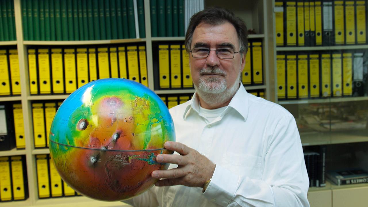Ralf Jaumann, Leiter der Abteilung für Planetengeologie beim Deutschen Zentrum für Luft- und Raumfahrt in Berlin-Adlershof mit einem Marsglobus, aufgenommen 2015