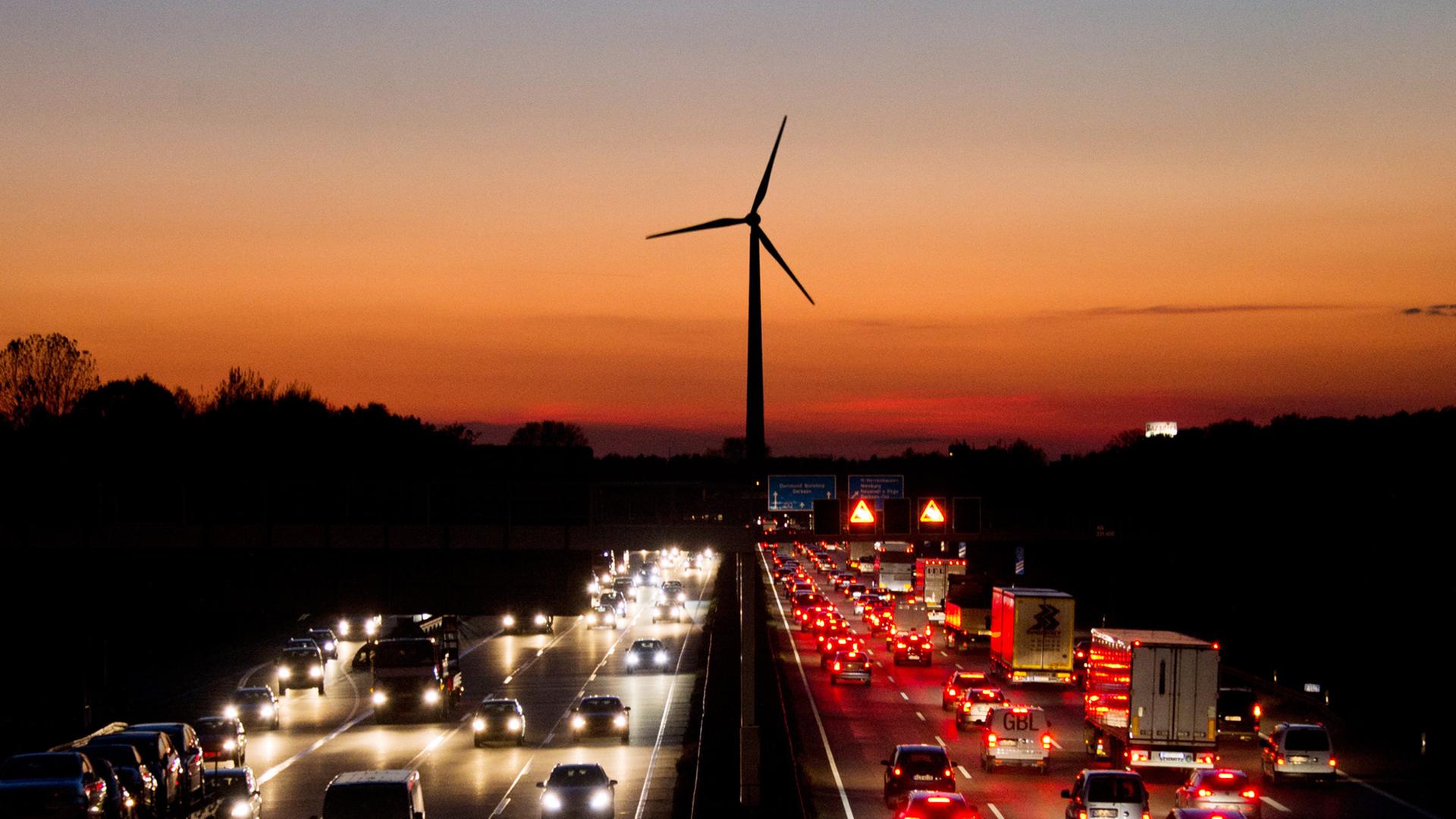 Die Autobahn 2 im Abendlicht, dahinter ein Windrad