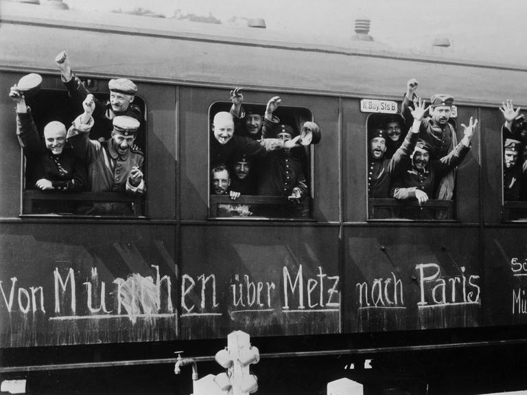 Zu sehen sind jubelnde Soldaten am Fenster eines Zuges, der sie im August 1914 an die Front des Ersten Weltkrieges bringt.