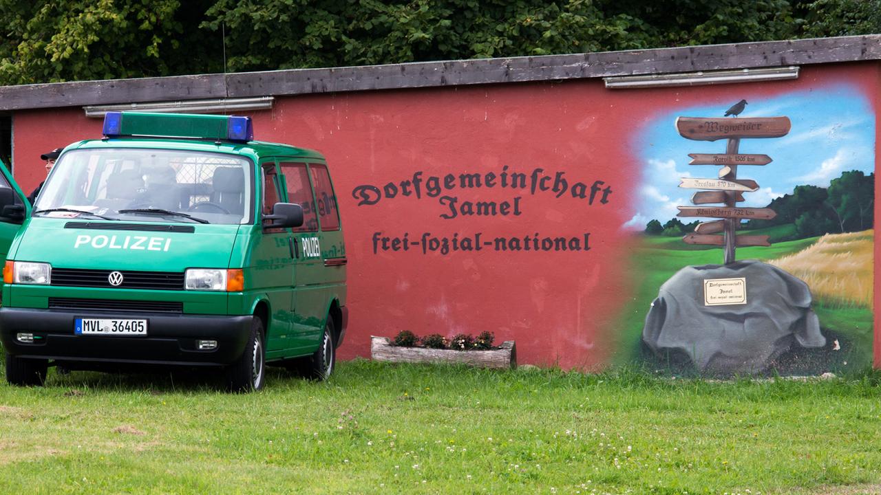Polizisten stehen am 30. August 2014 am Rande des Rockfestivals "Jamel rockt den Förster" in Jamel von einem von rechtsradikalen Dorfbewohnern bemalten Haus. Polizisten stehen am 30. August 2014 am Rande des Rockfestivals "Jamel rockt den Förster" in Jamel von einem von rechtsradikalen Dorfbewohnern bemalten Haus.