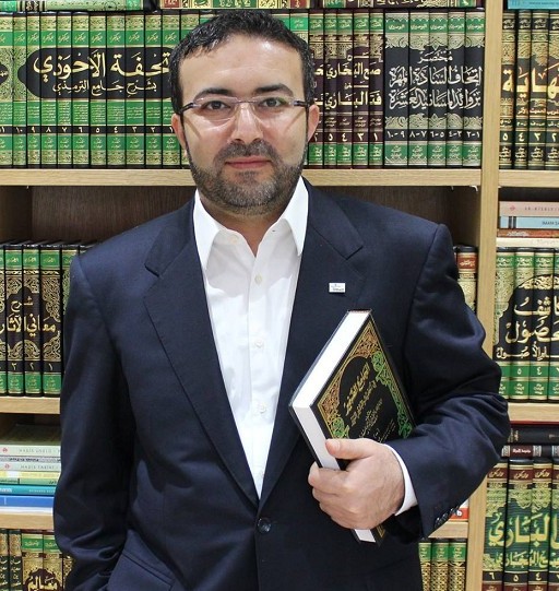 Professor Hüseyin İlker Çınar mit einem Buch in der Hand vor einem Bücherregal mit arabischen Büchern. Professor Hüseyin İlker Çınar mit einem Buch in der Hand vor einem Bücherregal mit arabischen Büchern.