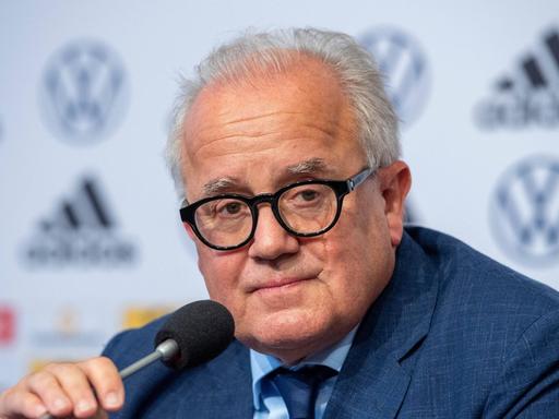 Der ehemalige Präsident des Deutschen Fußball-Bundes, Fritz Keller, sitzt auf einer Pressekonferenz und hat ein Mikrofon in der Hand. 