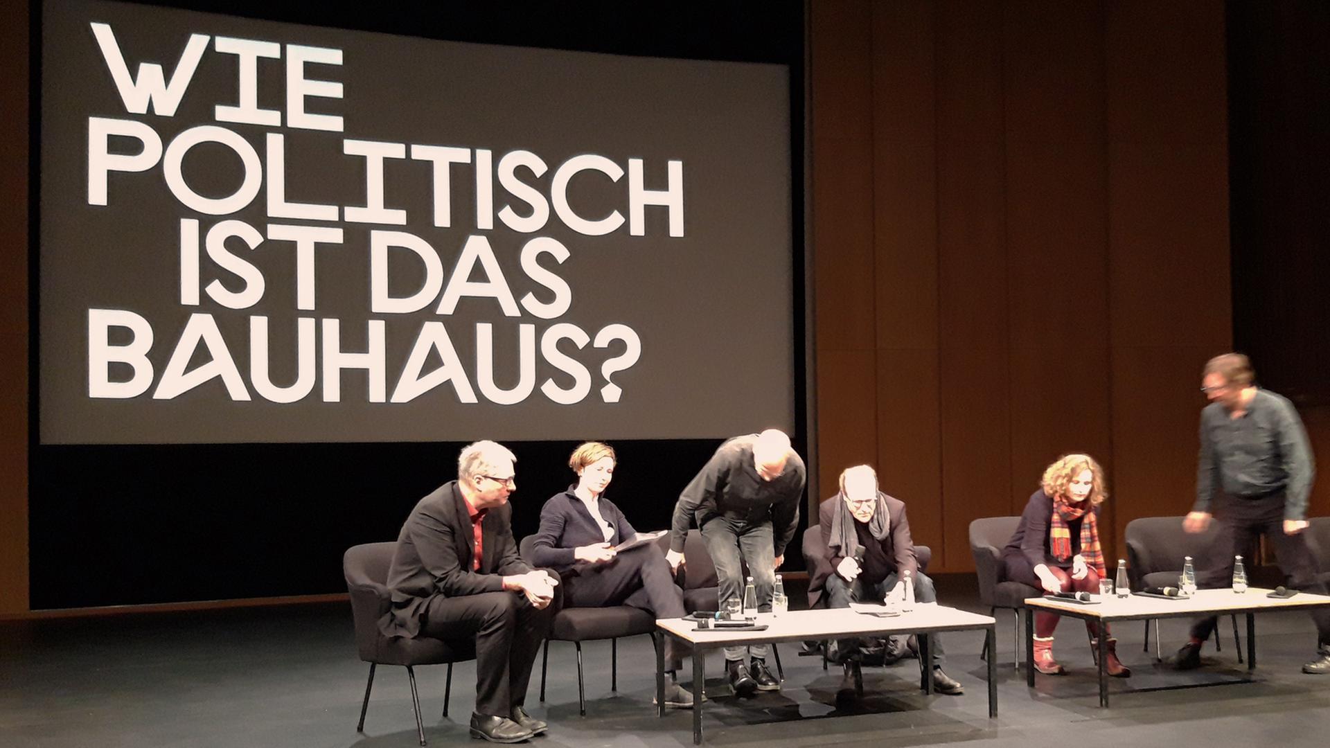 Blick auf die Bühne im Haus der Kulturen der Welt in Berlin: Mehrere Personen vor dem Schriftzug "Wie politisch ist das Bauhaus?" Blick auf die Bühne im Haus der Kulturen der Welt in Berlin: Mehrere Personen vor dem Schriftzug "Wie politisch ist das Bauhaus?"