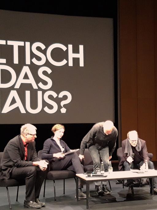 Blick auf die Bühne im Haus der Kulturen der Welt in Berlin: Mehrere Personen vor dem Schriftzug "Wie politisch ist das Bauhaus?"