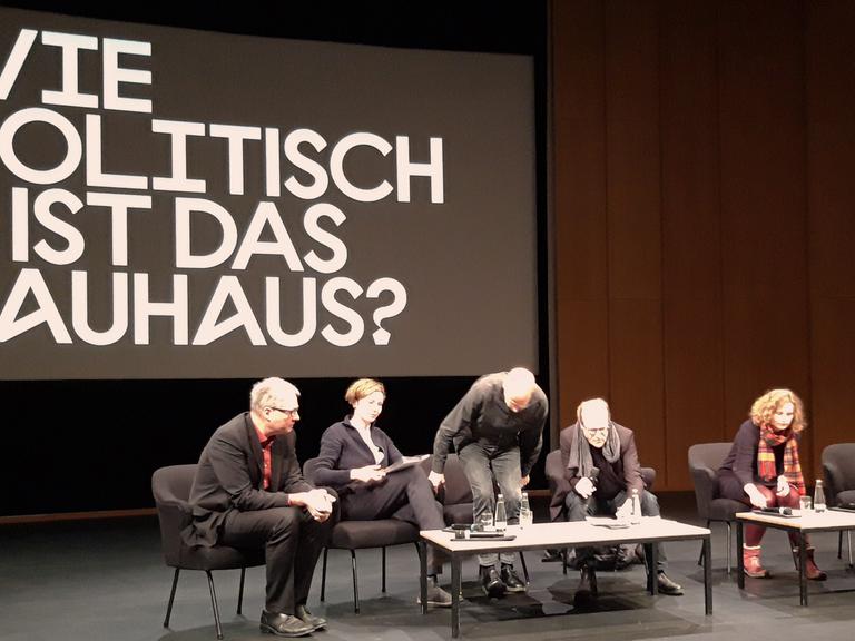 Blick auf die Bühne im Haus der Kulturen der Welt in Berlin: Mehrere Personen vor dem Schriftzug "Wie politisch ist das Bauhaus?"