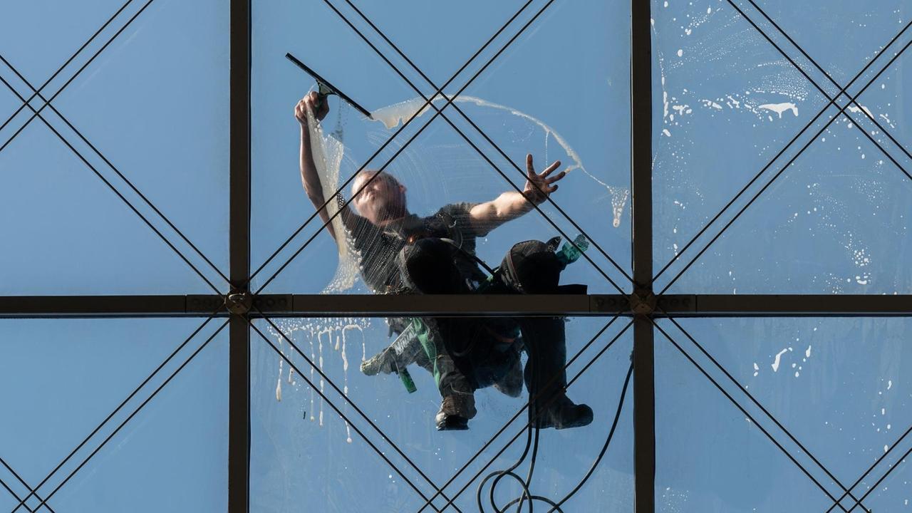 Ein spezialisierter Glas- und Gebäudereiniger der Dresdner Firma Purel putzt in 27 Meter Höhe das gläserne Dach des World Trade Centers