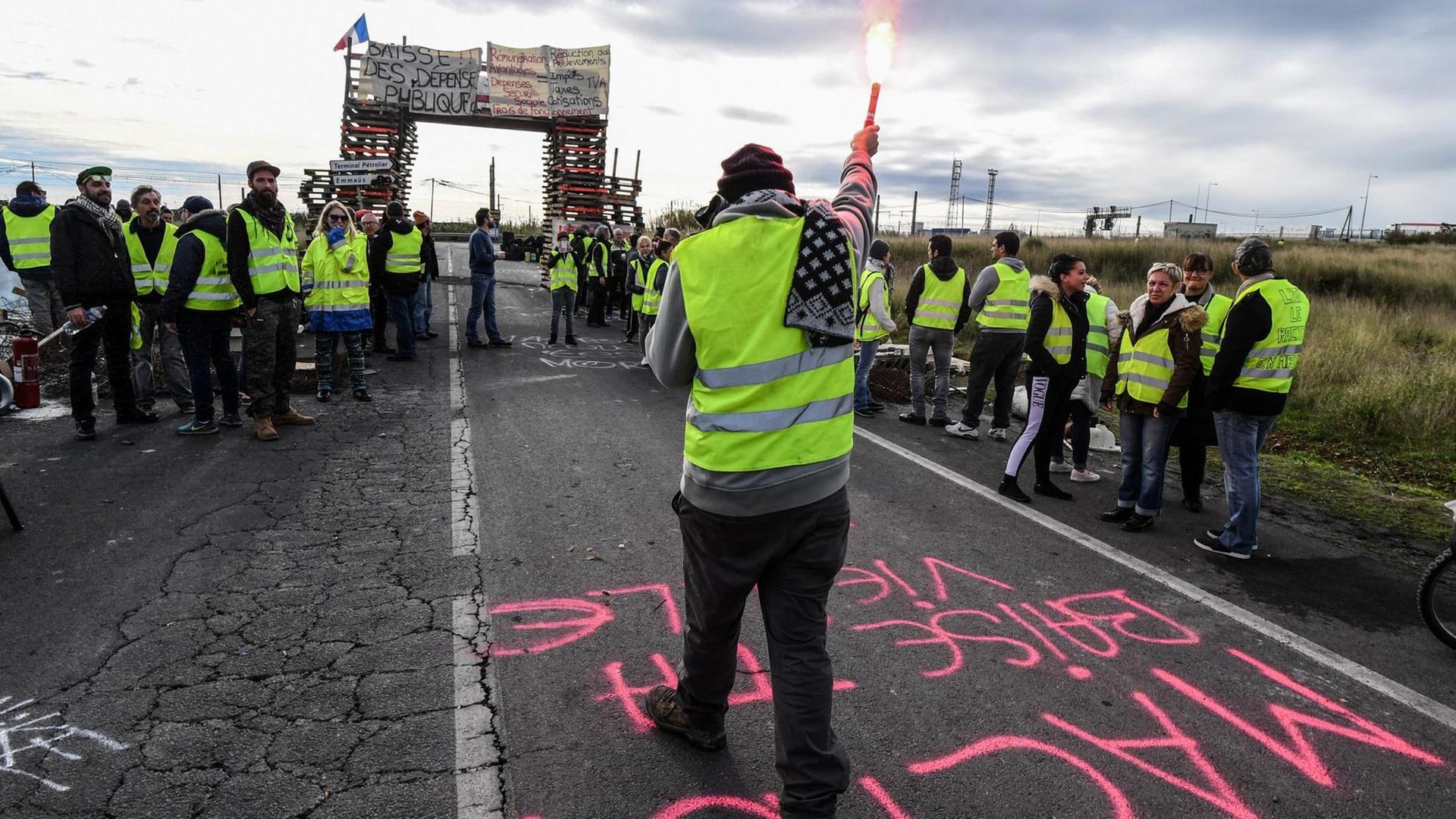 Demonstranten der Gelben Westen (Gilets Jaunes) blockieren die Straße, die zum Öldepot Frontignan in Südfrankreich führt, als sie gegen den Anstieg der Treibstoffpreise und der Lebenshaltungskosten am 3. Dezember 2018 demonstrieren. Demonstranten der Gelben Westen (Gilets Jaunes) blockieren die Straße, die zum Öldepot Frontignan in Südfrankreich führt, als sie gegen den Anstieg der Treibstoffpreise und der Lebenshaltungskosten am 3. Dezember 2018 demonstrieren.