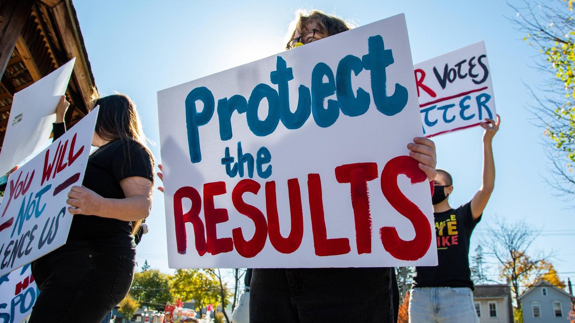 "Protect the results" steht auf einem Plakat von Demonstranten. "Protect the results" steht auf einem Plakat von Demonstranten.