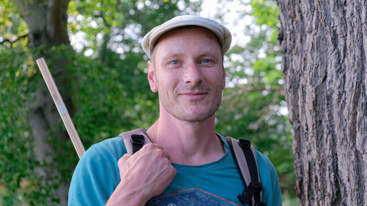 Tobias Scharnweber steht neben einem alten Baum. Tobias Scharnweber steht neben einem alten Baum.