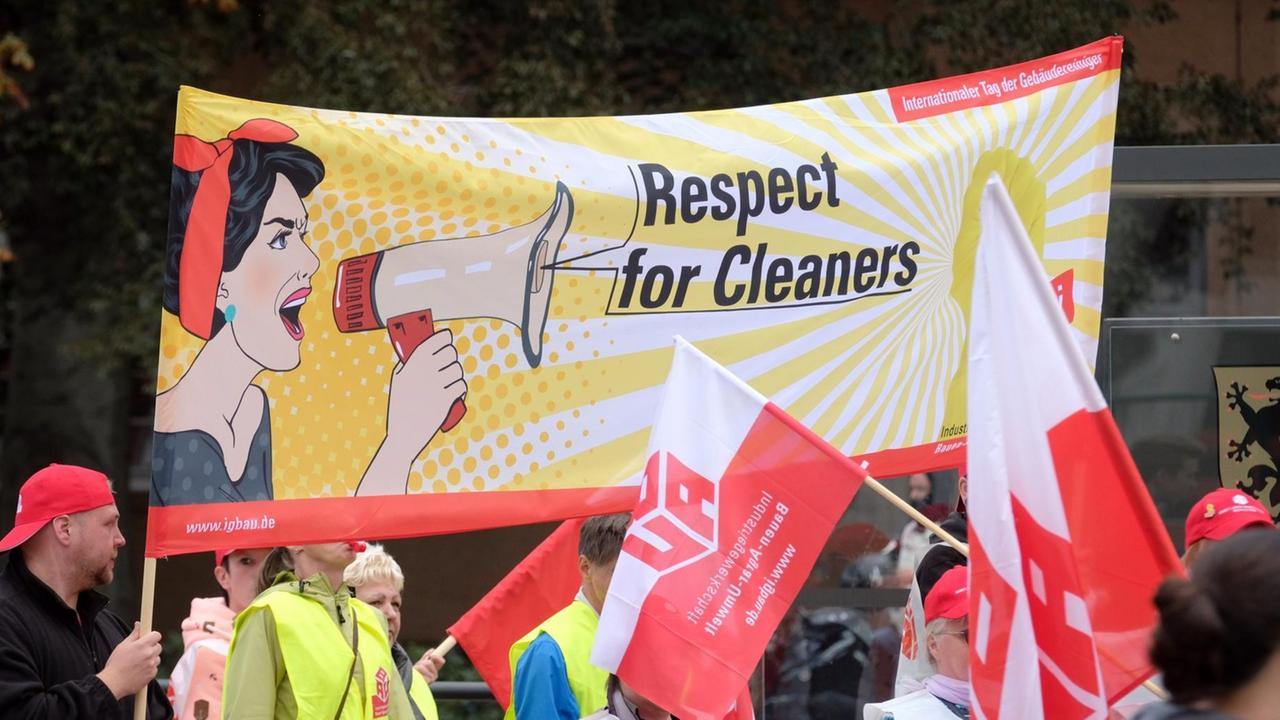 Teilnehmer einer Demonstration gehen mit einem Transparent "Respect for Cleaners" durch das Stadtzentrum. Teilnehmer einer Demonstration gehen mit einem Transparent "Respect for Cleaners" durch das Stadtzentrum.