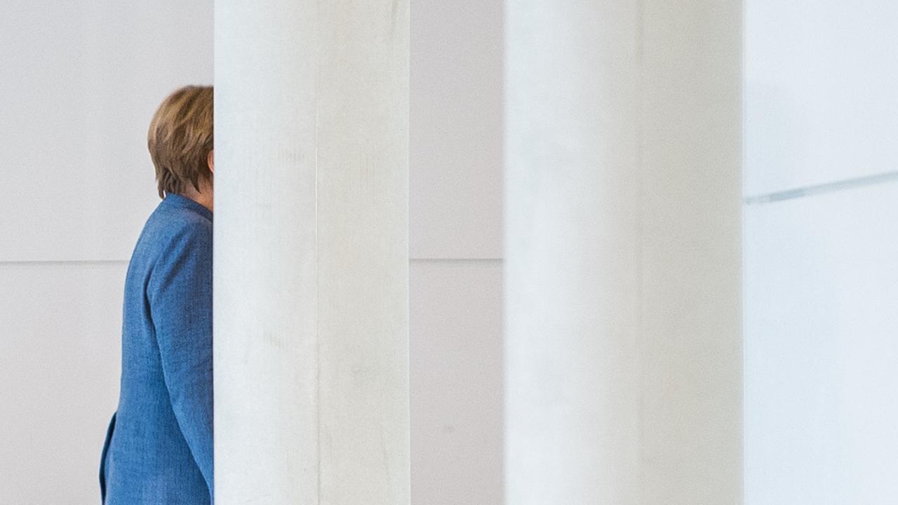 BundeskanzlerinAngela Merkel geht im Bundestag in Berlin und wird dabei halb von einer Säule verdeckt. BundeskanzlerinAngela Merkel geht im Bundestag in Berlin und wird dabei halb von einer Säule verdeckt.