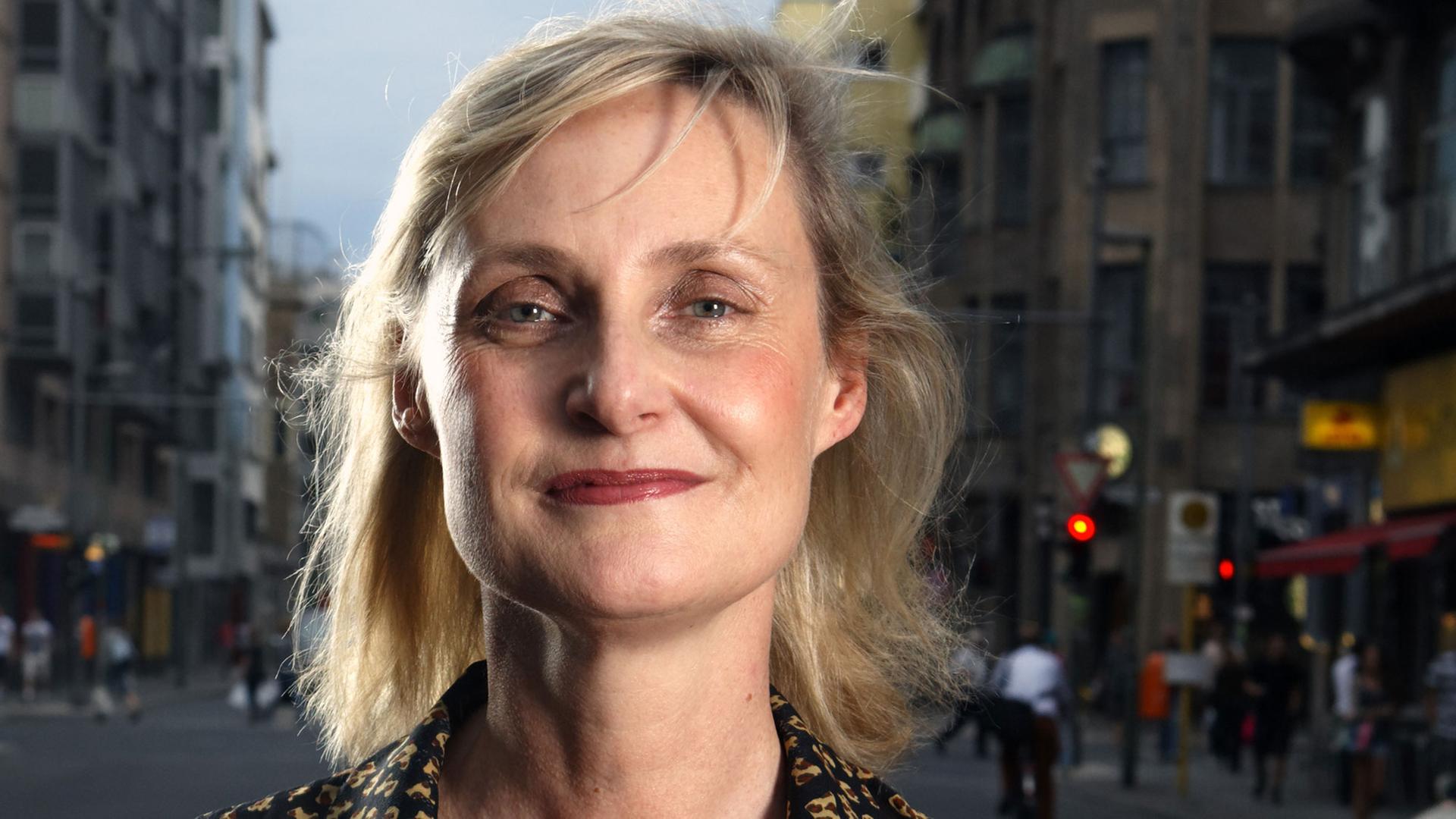 Die Verlegerin und Literaturagentin Elisabeth Ruge, im Hintergrund ist eine Straßenkulisse zu sehen Die Verlegerin und Literaturagentin Elisabeth Ruge, im Hintergrund ist eine Straßenkulisse zu sehen