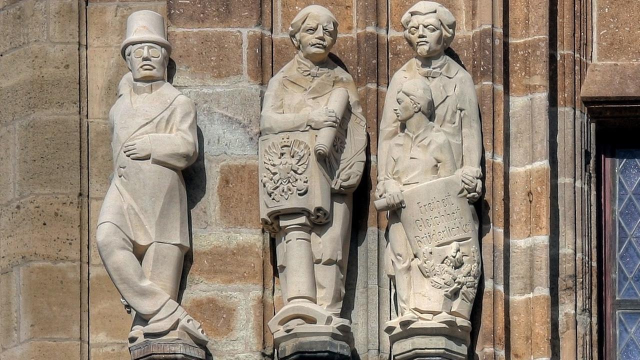 Jaques Offenbachs als Steinfigurine an einer historischen Steinfassade in einer Reihe anderer historischer Figuren Jaques Offenbachs als Steinfigurine an einer historischen Steinfassade in einer Reihe anderer historischer Figuren