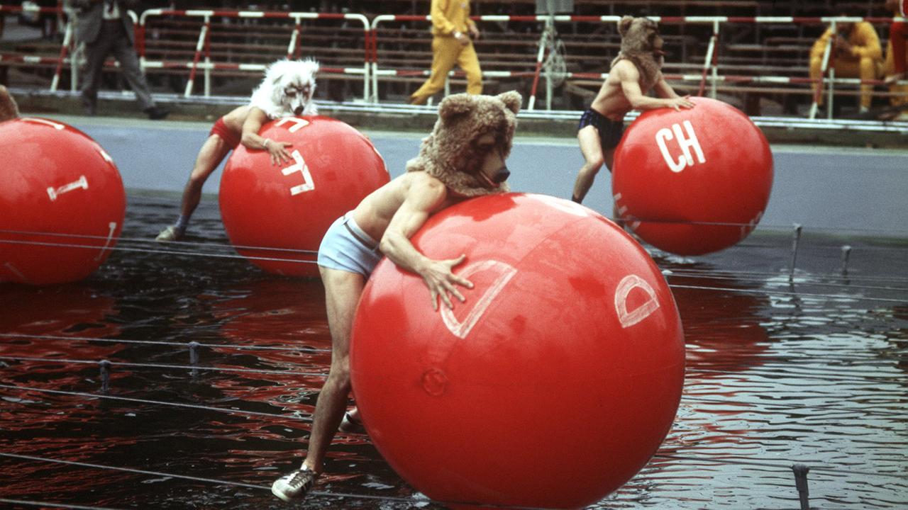 Die beliebte TV-Show "Spiel ohne Grenzen" 1970 in Berlin: Die Teilnehmer rollen auf Drahtseilen balancierend rote Bälle über ein Wasserbecken. Die beliebte TV-Show "Spiel ohne Grenzen" 1970 in Berlin: Die Teilnehmer rollen auf Drahtseilen balancierend rote Bälle über ein Wasserbecken.