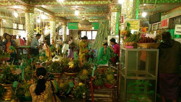 Frauen flüstern einer Heiligenstatue Geheimnisse zu - Botataung Paya, Rangun