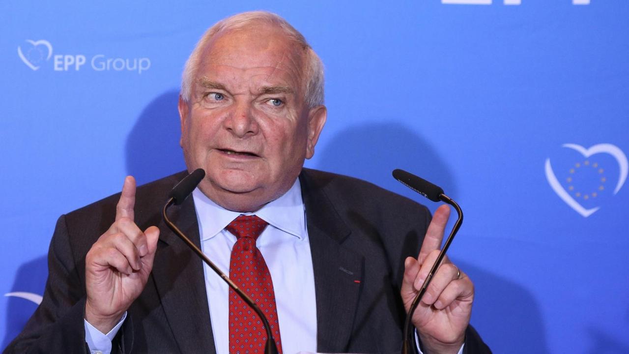Daul spricht vor einer blauen Wand mit dem EPP-Schriftzug in zwei Mikrofone und hebt beide Zeigefiner in Schulterhöhe. Daul spricht vor einer blauen Wand mit dem EPP-Schriftzug in zwei Mikrofone und hebt beide Zeigefiner in Schulterhöhe.