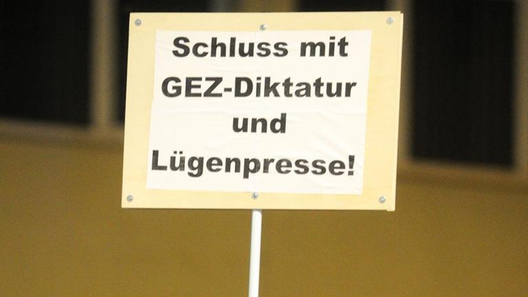 Ein Pappschildl: "Schluss mit der GEZ-Diktatur und Lügenpresse". Ein Pappschildl: "Schluss mit der GEZ-Diktatur und Lügenpresse".