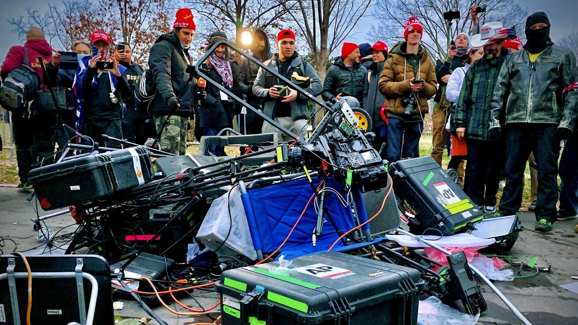 Zerstörtes Medien-Equipment liegt am 06.01.2021 vor einer Gruppe von Trump-Angängern auf dem Boden vor dem Kapitol in Washington, DC. - Zerstörtes Medien-Equipment liegt am 06.01.2021 vor einer Gruppe von Trump-Angängern auf dem Boden vor dem Kapitol in Washington, DC. -