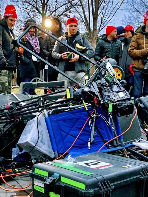 Zerstörtes Medien-Equipment liegt am 06.01.2021 vor einer Gruppe von Trump-Angängern auf dem Boden vor dem Kapitol in Washington, DC. -