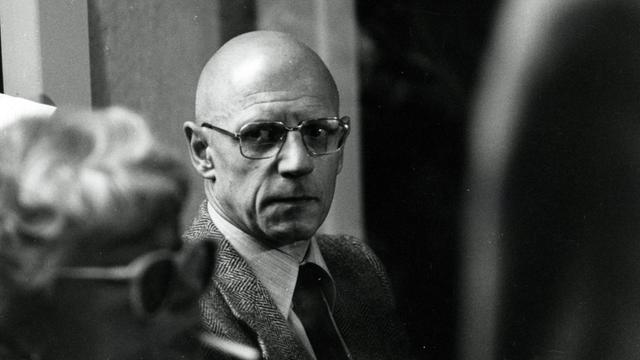 Der französische Philosoph Michel Foucault, aufgenommen 1980, im Bildvordergrund ist eine Frau zu sehen