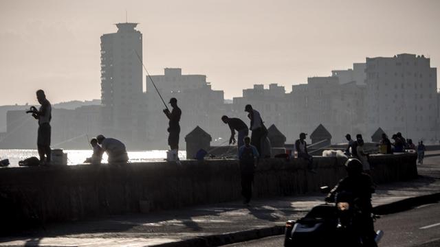 Angler stehen am Malécon, der Uferpromenade in Havanna (Kuba).