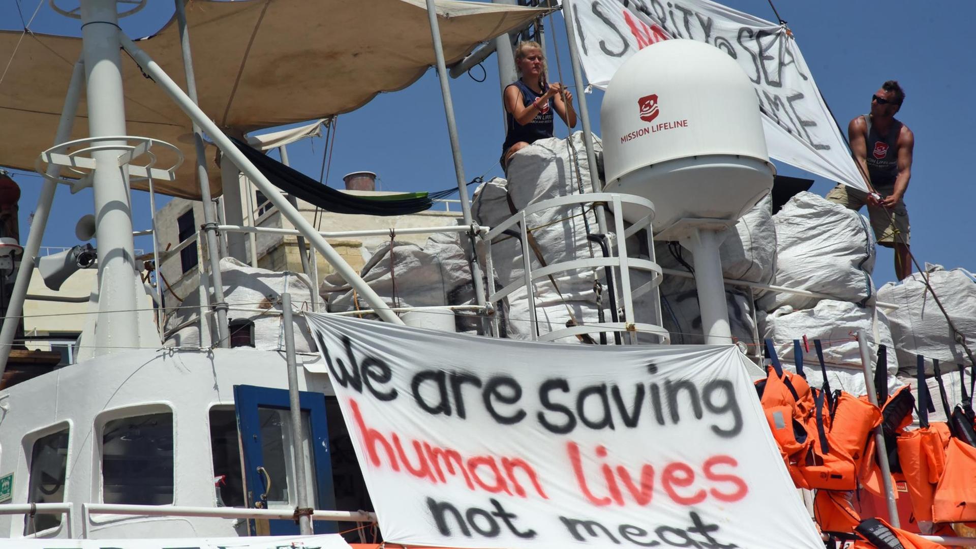 Das deutsche Seenotrettungsschiff "Lifeline" liegt im Hafen von Malta, wo es seit Ende Juni festgehalten wird. An Bord hat die Besatzung Transparente angabracht, auf denen steht "We are saving human lives not meeast" (Wir retten Menschenleben, kein Fleisch)