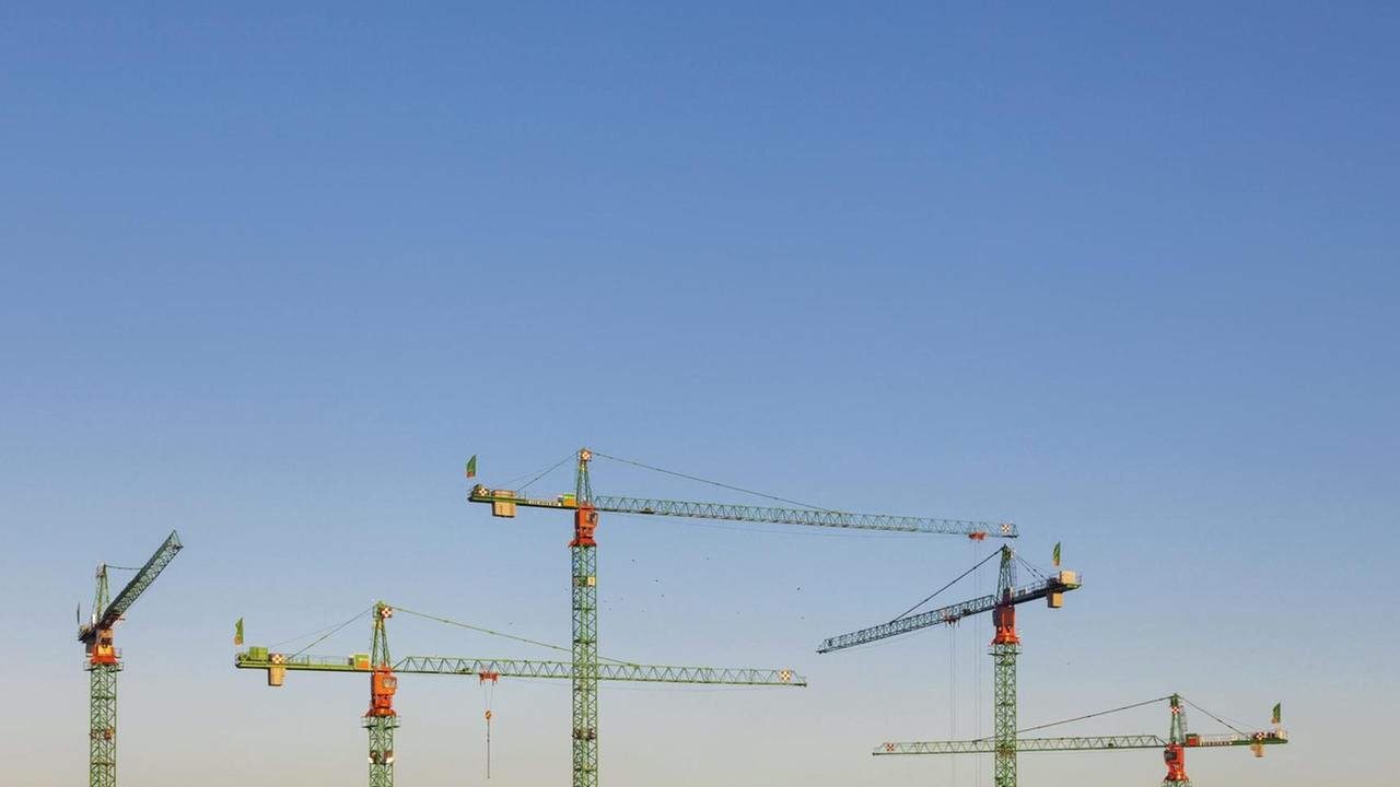 Baukräne in Berlin recken sich in den blauen Himmel. Baukräne in Berlin recken sich in den blauen Himmel.
