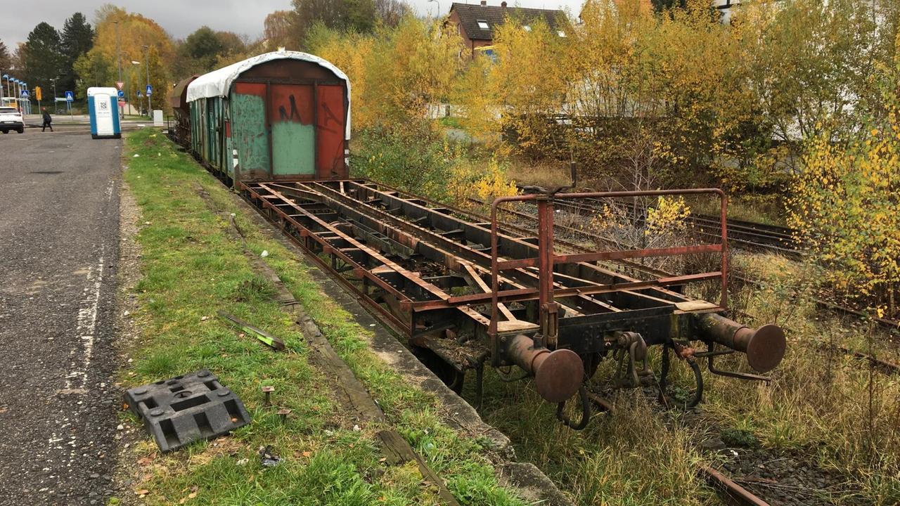 Auf einem zugewucherten Bahngleis stehen alte, rostige Güterwagons. Auf einem zugewucherten Bahngleis stehen alte, rostige Güterwagons.