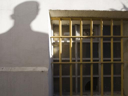 Der Schatten einer Person neben einem Gitterfenster des ehemaligen Jugendwerkhofes Torgau in der heutigen Gedenkstätte in Torgau/Sachsen.