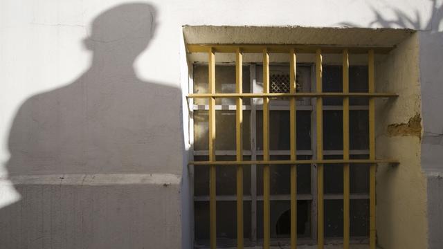 Der Schatten einer Person neben einem Gitterfenster des ehemaligen Jugendwerkhofes Torgau in der heutigen Gedenkstätte in Torgau/Sachsen.