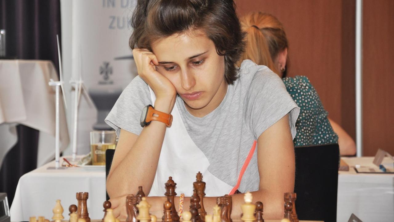 Die junge Schachspielerin Filiz Osmanodja schaut nachdenklich auf ein Schachbrett.