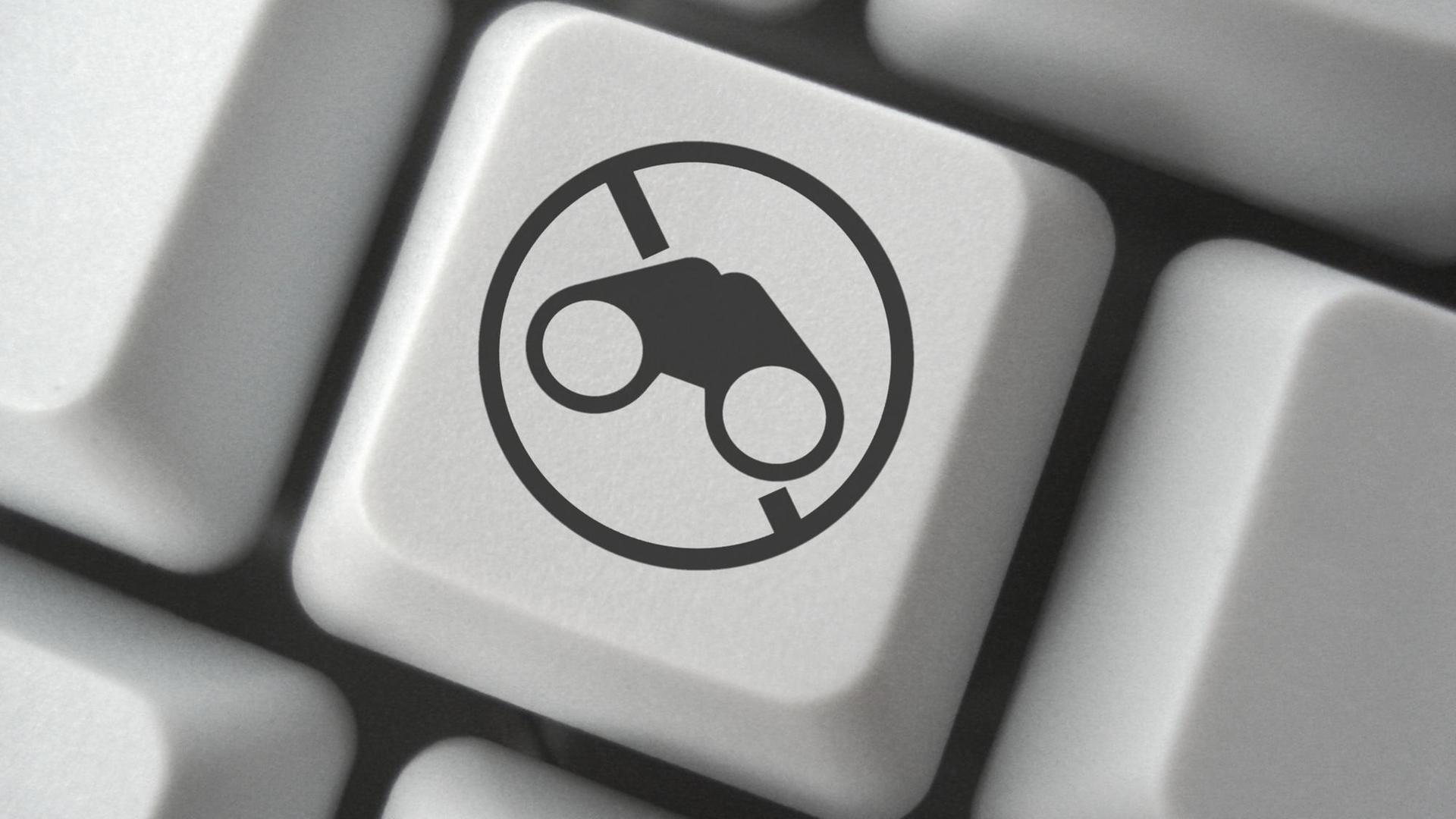 Eine Tastatatur mit einer Anti-Spionage-Taste, die ein durchgestrichenes Fernglas zeigt. Eine Tastatatur mit einer Anti-Spionage-Taste, die ein durchgestrichenes Fernglas zeigt.
