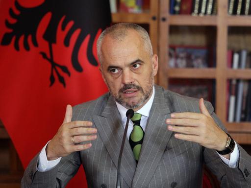Albaniens Premier Edi Rama sitzt am Schreibtisch vor der roten Flagge seines Landes und erläutert den EU-Kandidatenstatus