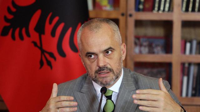 Albaniens Premier Edi Rama sitzt am Schreibtisch vor der roten Flagge seines Landes und erläutert den EU-Kandidatenstatus
