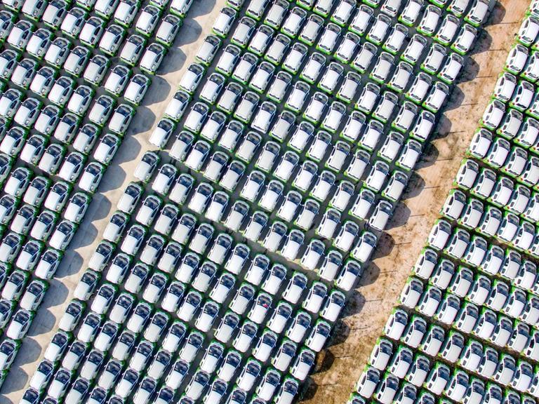 Ein riesen Parkplatz voller chinesischer Elektroautos in Reihen.