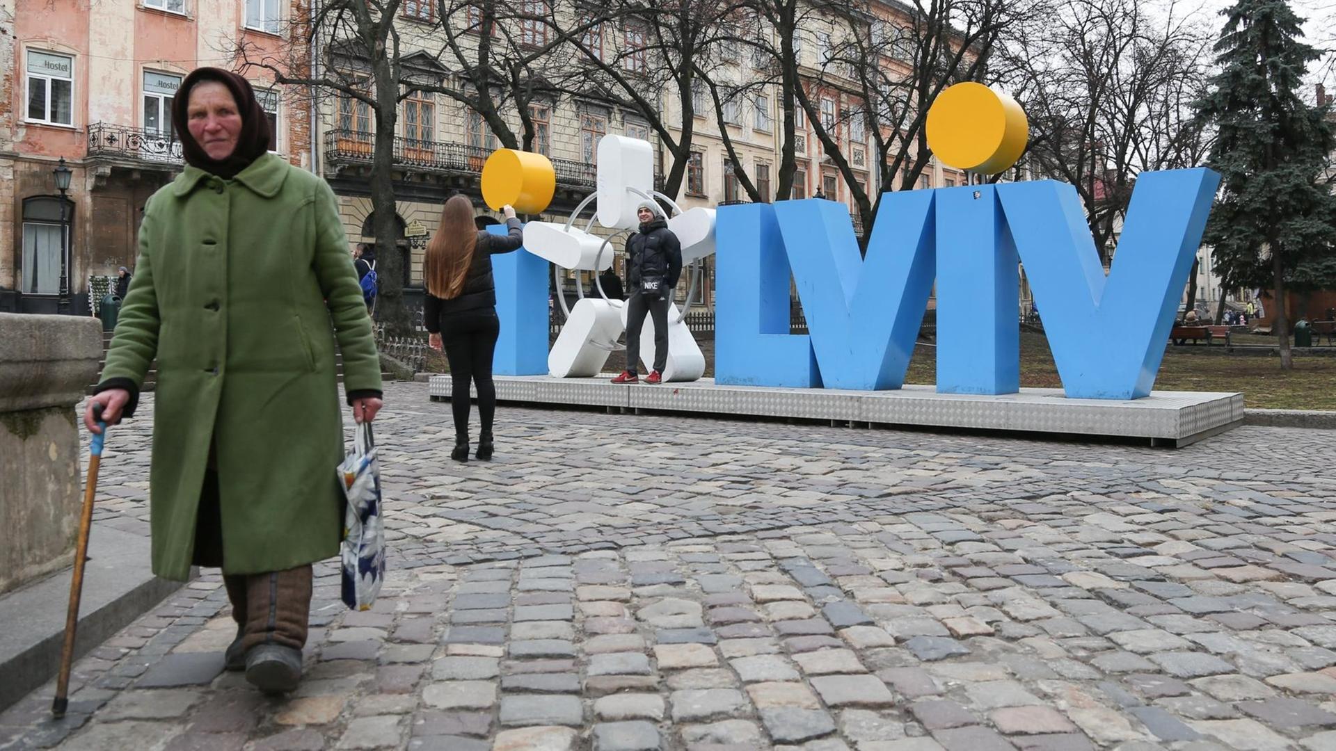 Eine alte Frau ist am 18.02.2016 im ukrainischen Lemberg (Lwiw) vor einer städtischen Skulptur zu sehen. Eine alte Frau ist am 18.02.2016 im ukrainischen Lemberg (Lwiw) vor einer städtischen Skulptur zu sehen.