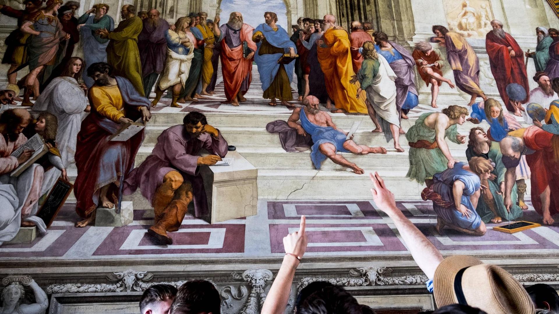 Touristen zeigen auf einzelne Figuren aus Raffaels "Schule von Athen" Touristen zeigen auf einzelne Figuren aus Raffaels "Schule von Athen"