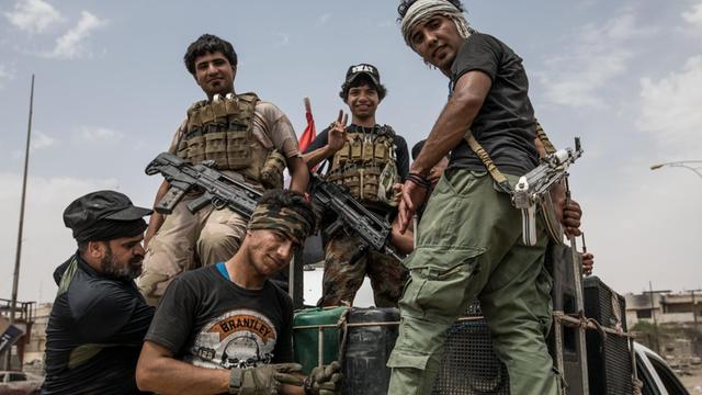 Fünf Männer, Mitglieder der schiitischen "Hashd al-Shaabi"-Milizen auf einem Militär-Lkw. in West Mosul.