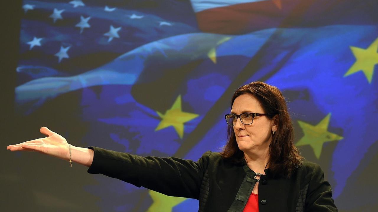 Malmström steht vor einer Videowand mit den Fahnen Europas udn der EU. Sie weist mit einer ausladenden Bewegung der rechten Hand zur Seite. Malmström steht vor einer Videowand mit den Fahnen Europas udn der EU. Sie weist mit einer ausladenden Bewegung der rechten Hand zur Seite.
