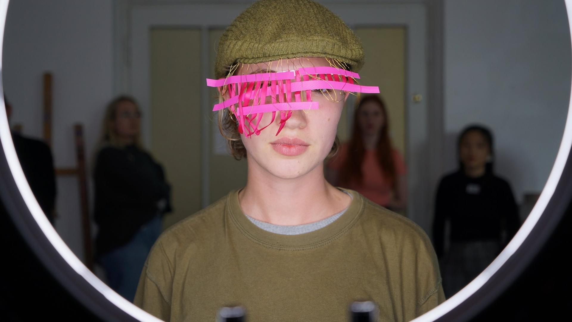 Eine junge Frau trägt eine Maske vor dem Gesicht Eine junge Frau trägt eine Maske vor dem Gesicht