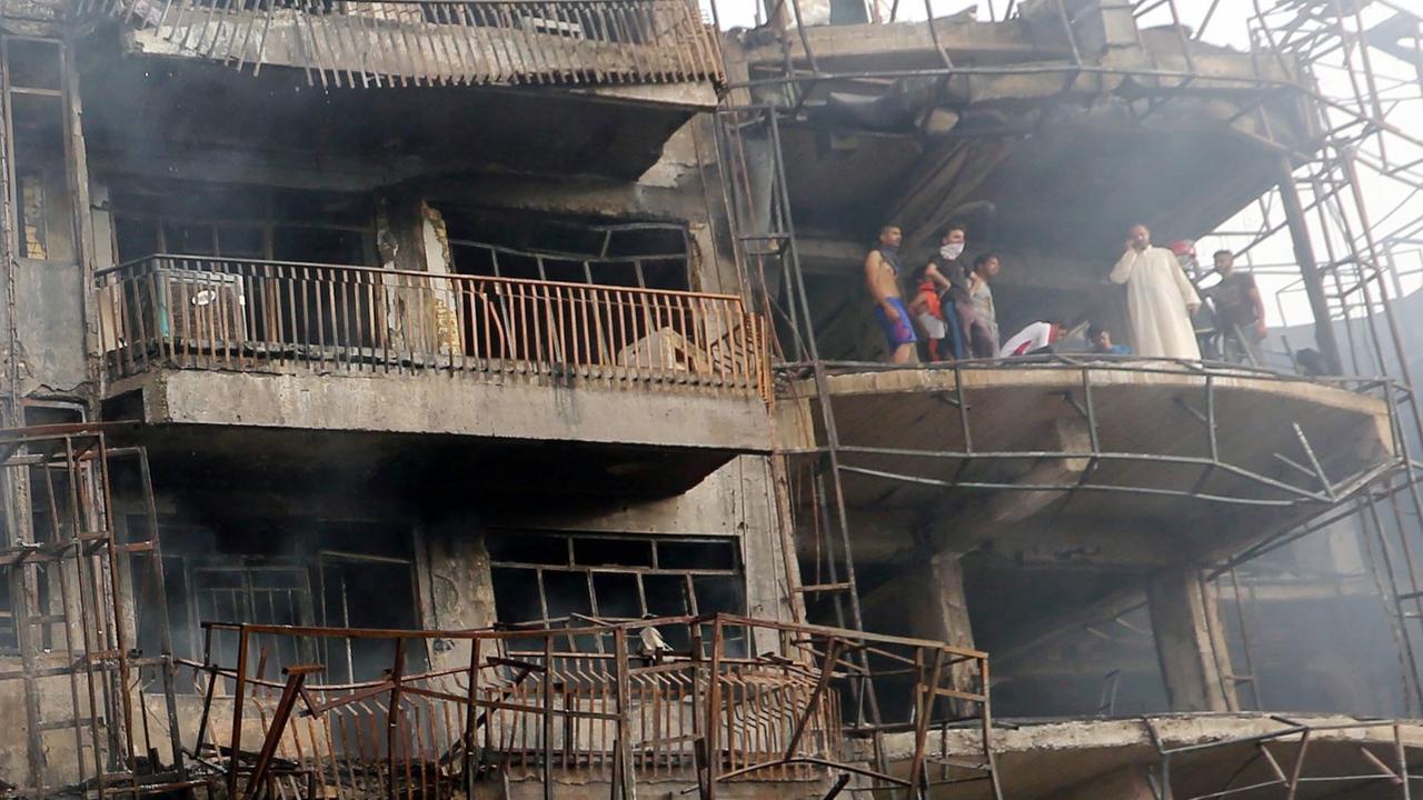 Ein Haus im Karrada-Viertel im Zentrum der Stadt Bagdad, Irak, das bei einem Sprengstoffanschlag zerstört wurde. Bewohner schauen sich die Schäden an. Ein Haus im Karrada-Viertel im Zentrum der Stadt Bagdad, Irak, das bei einem Sprengstoffanschlag zerstört wurde. Bewohner schauen sich die Schäden an.