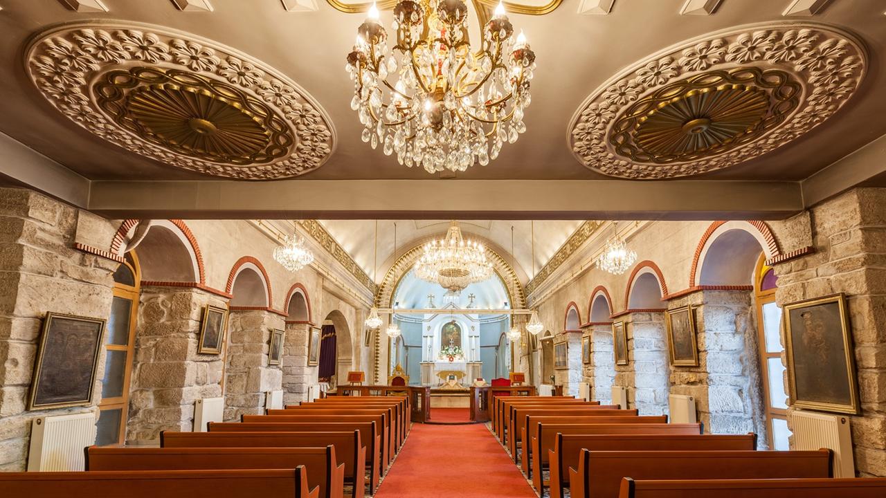 Blick in ein kleines Kirchenschiff mit Stuck und schlichten Holzbänken. Blick in ein kleines Kirchenschiff mit Stuck und schlichten Holzbänken.
