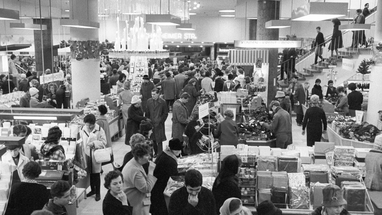 Blick in ein Frankfurter Kaufhaus am 3.12.1963, Schwarz-Weiß-Aufnahme, Menschen stehen an Kassen und Verkaufsständen Blick in ein Frankfurter Kaufhaus am 3.12.1963, Schwarz-Weiß-Aufnahme, Menschen stehen an Kassen und Verkaufsständen